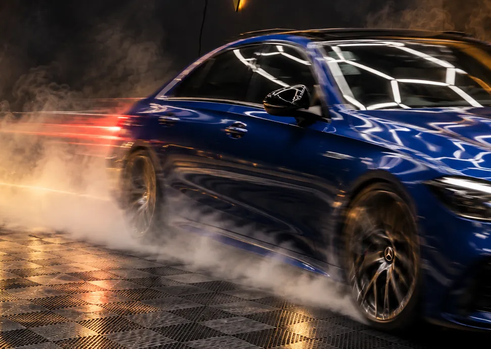 Mercedes saindo do estúdio entre a fumaça