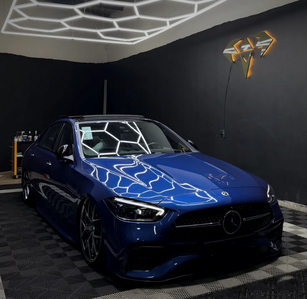 Foto do estúdio Black Diamond com a Mercedes azul sob a luz hexagonal